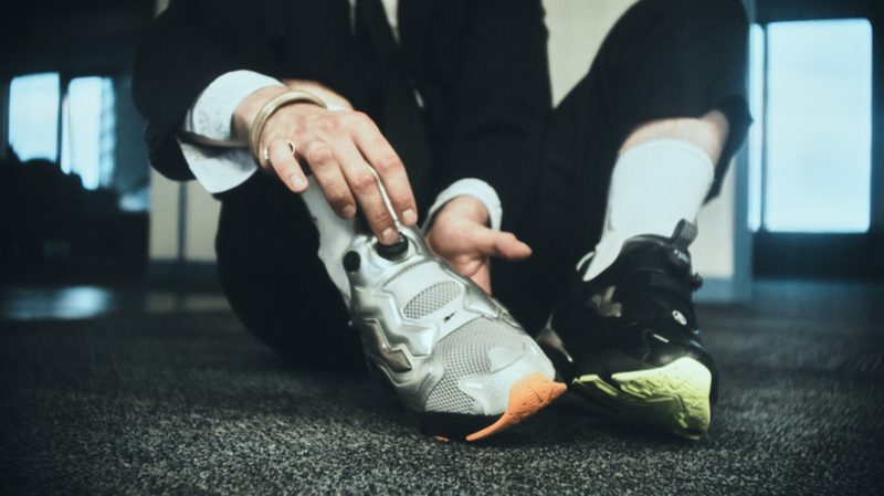 man wearing one black and one silver sneaker