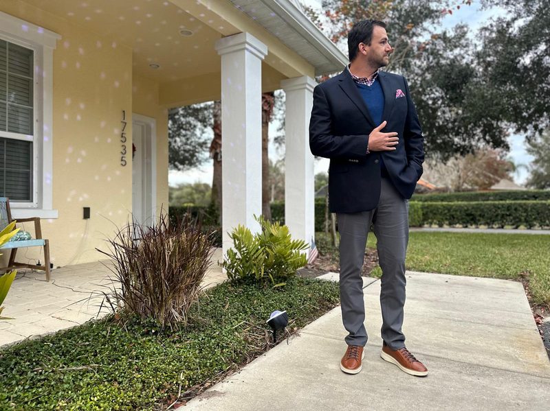 Man in blue sport coat and gray pants