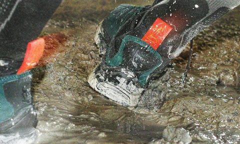lifestyle photo of salomon sneakers in mud