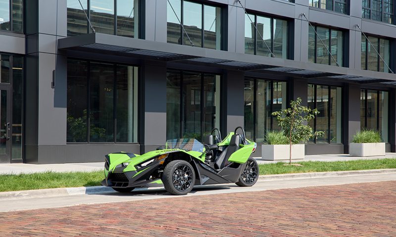 2025 Polaris Slingshot SL parked on the side of a street in front of an office building.