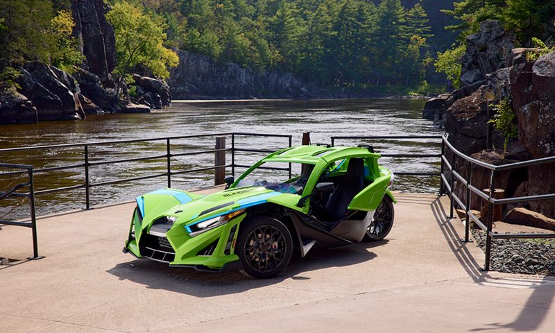 2025 Polaris Slingshot SL with an optional color-matched top parked next to a river.
