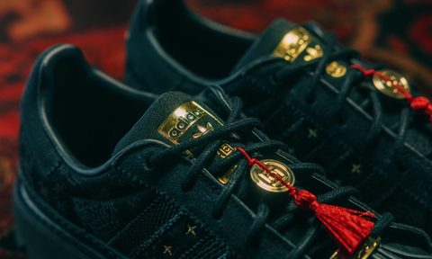 close up on laces of black sneakers on red carpet