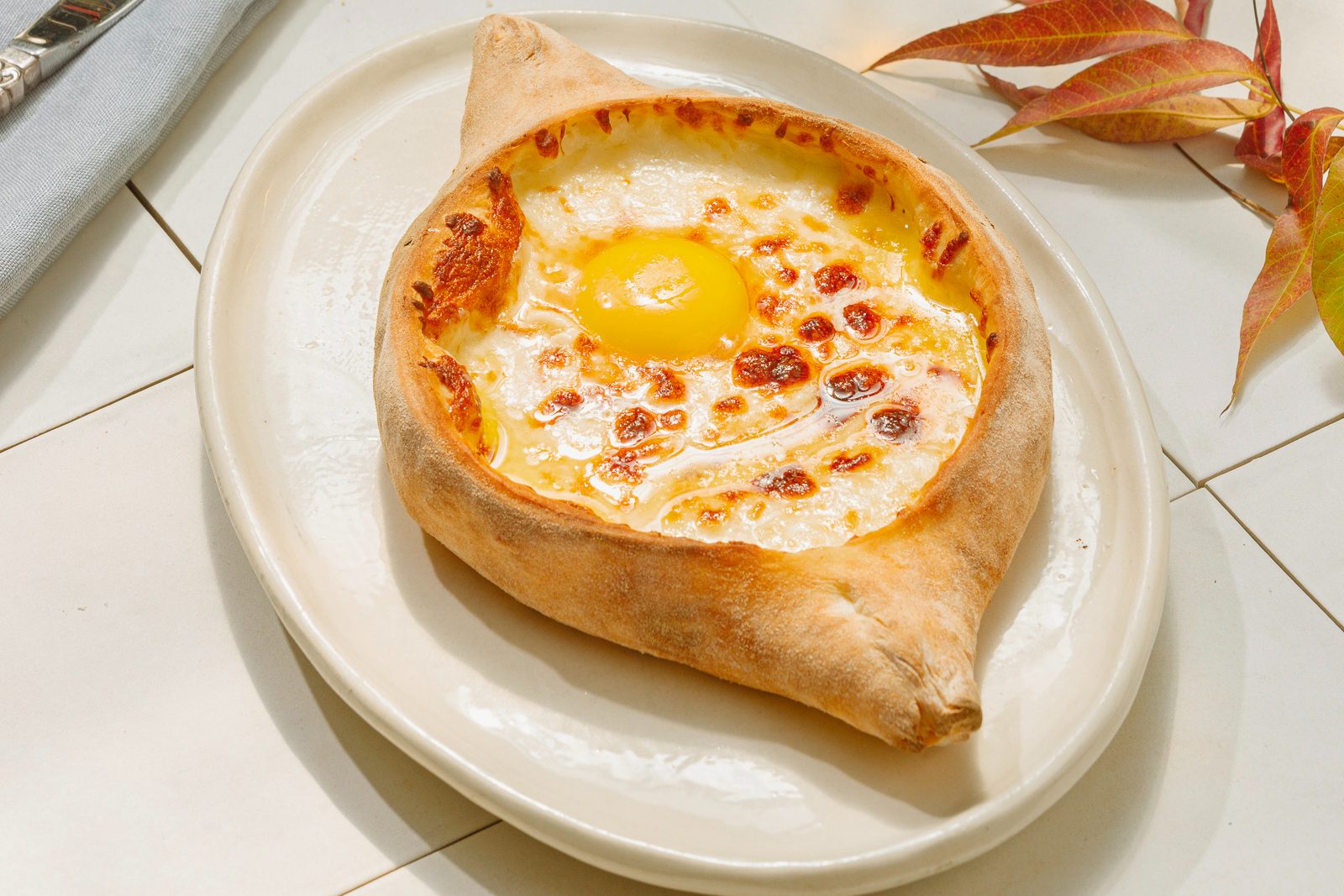 adjaruli khachapuri on white plate.