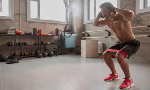 man doing surrender squats in gym