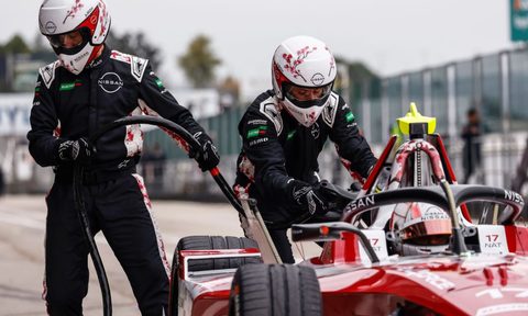 Two mechanics with Formula E Pit Boost battery charging during a race.