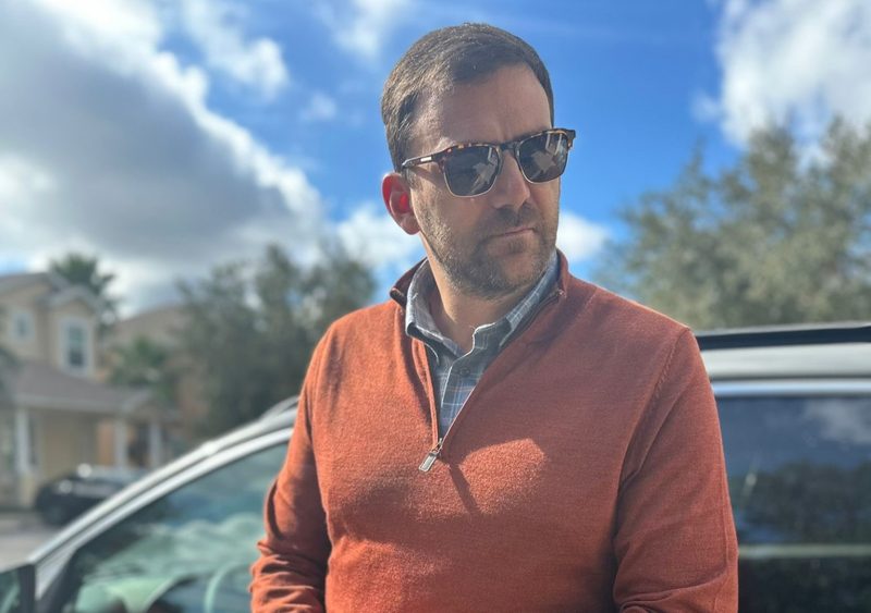 Man in orange sweater and sunglasses