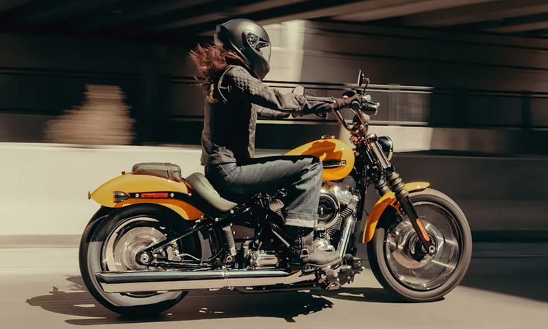 Rider on a 2025 Harley-Davidson Street Bob driving on a highway underpass.