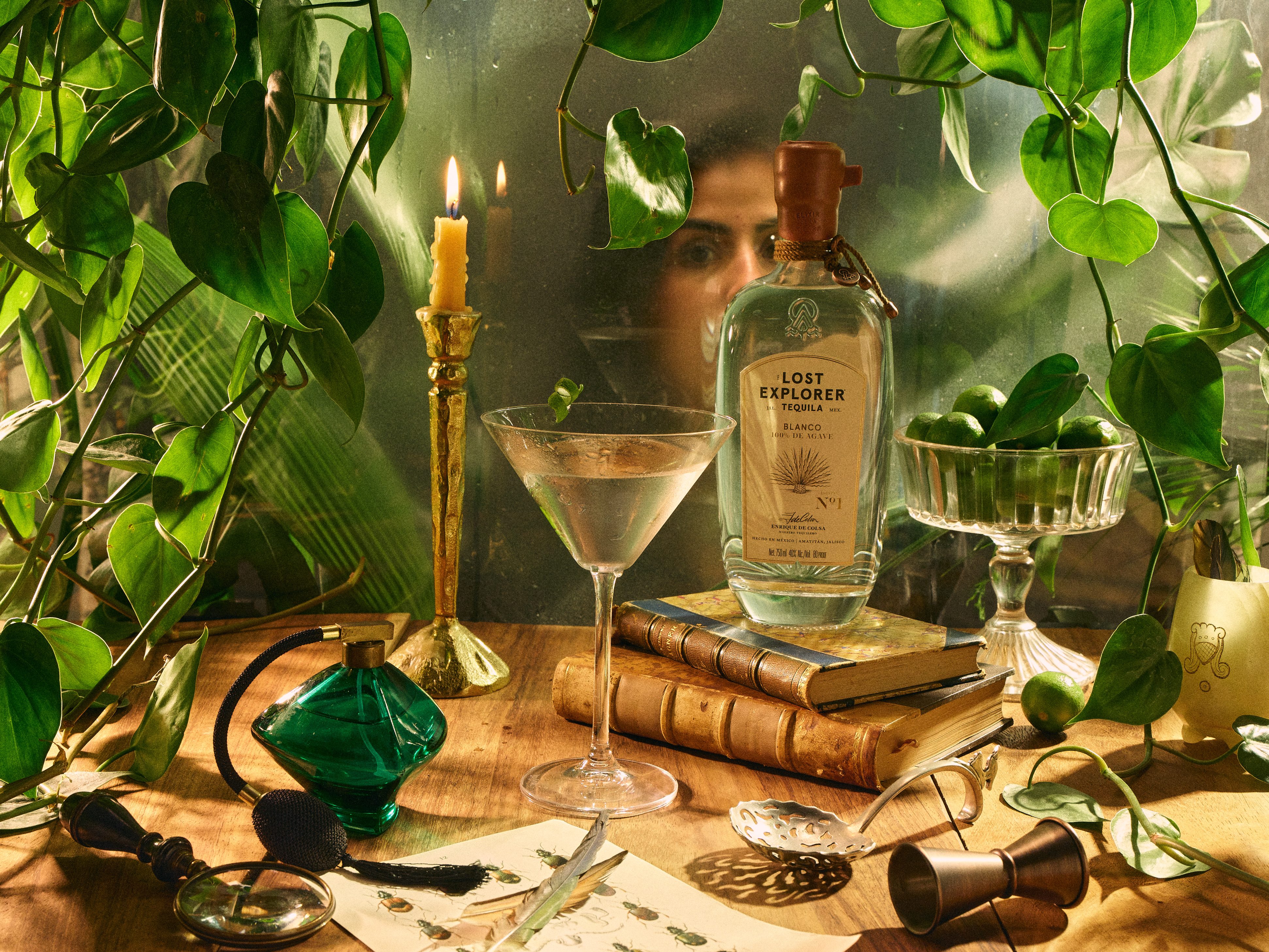 A tequila martini on a book with a woman's face reflected in the background for some reason