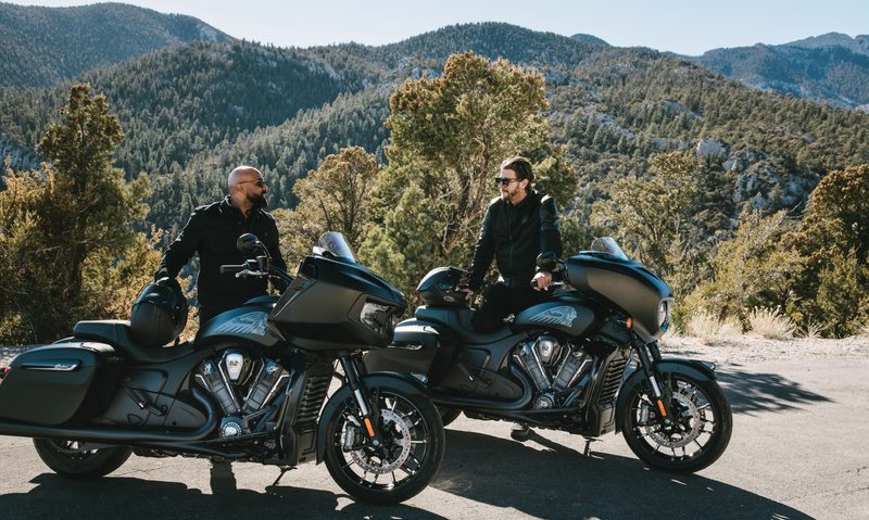 Two riders 2025 Indian Chieftain PowerPlus and Challenger PowerPlus baggers on the side of the road with rolling hills in the background.