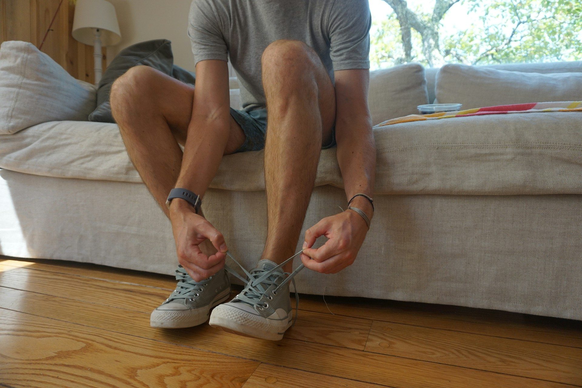 man putting on and tying shoes