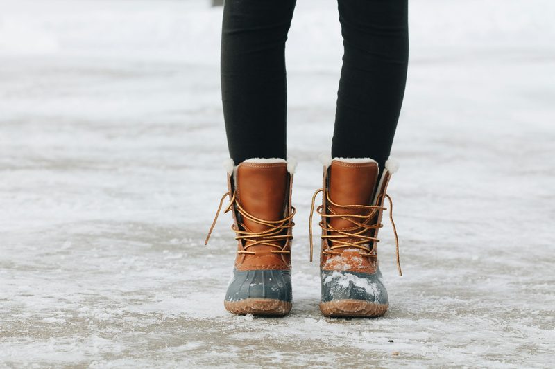 Person wearing winter boots while walking on ice