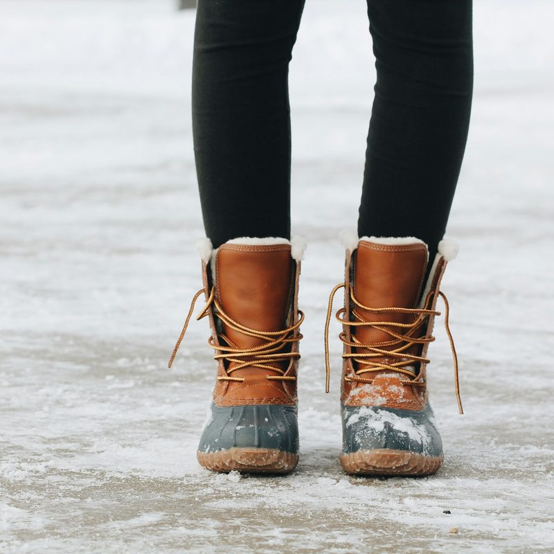 Person wearing winter boots while walking on ice