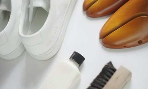 pair of shoes, shoe fill, and shoe brush on a table