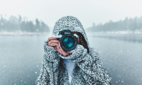Woman taking a photo in a snowy landscape