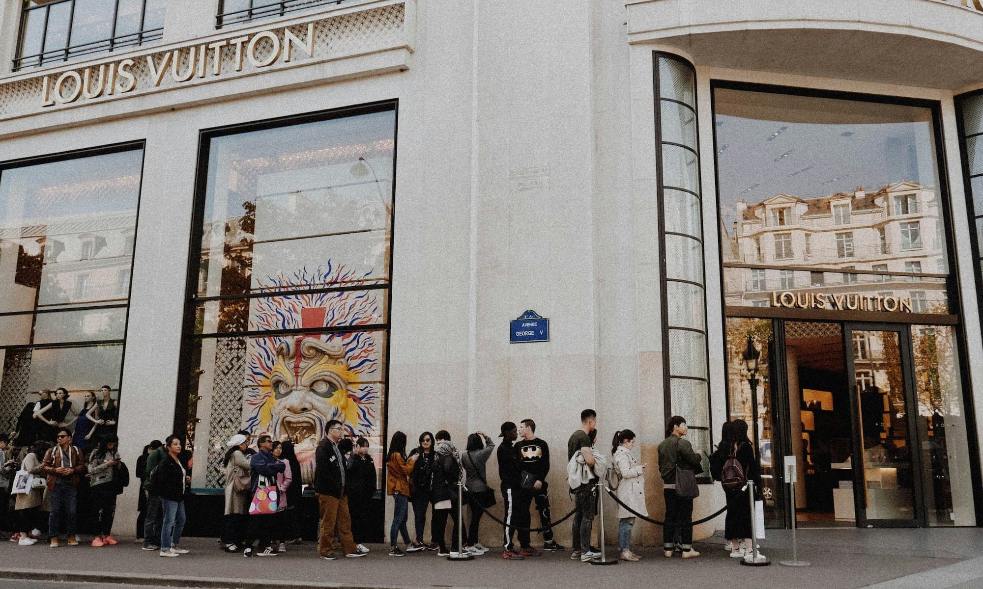 people waiting in line outside louis vuitton store