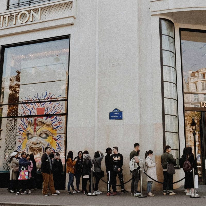 People waiting in line outside Louis Vuitton store