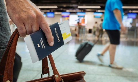 Man holding a passport in his hand at the airport