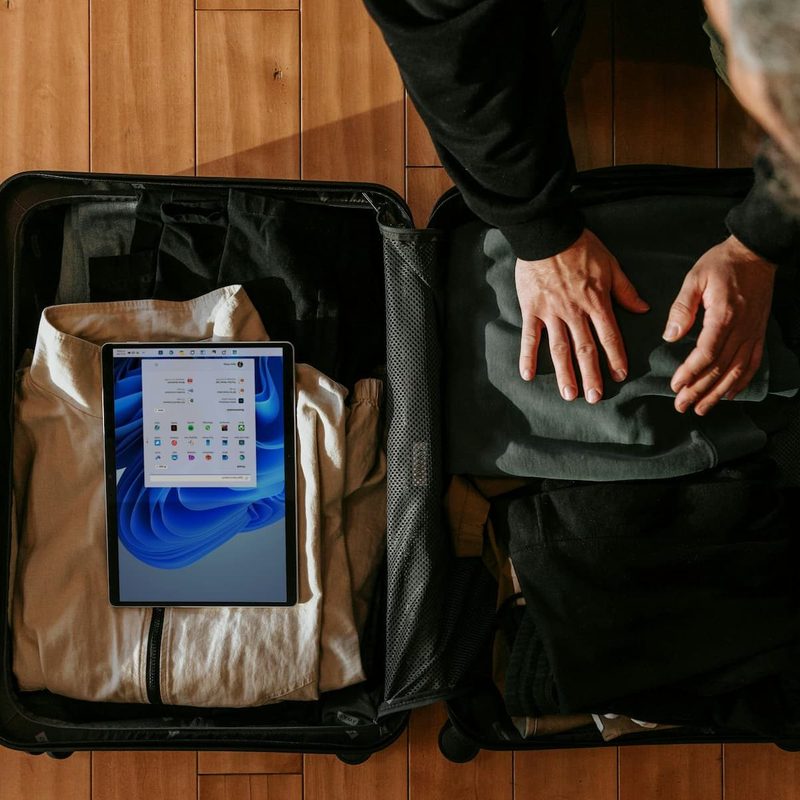 An overhead view of a man packing a suitcase