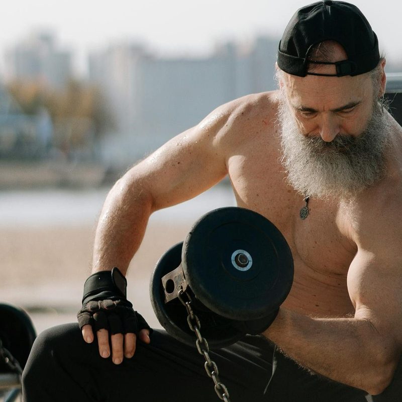 older man strong muscle muscular concentration curl dumbbell