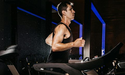 man running wearing black vest on treadmill cardio aerobic