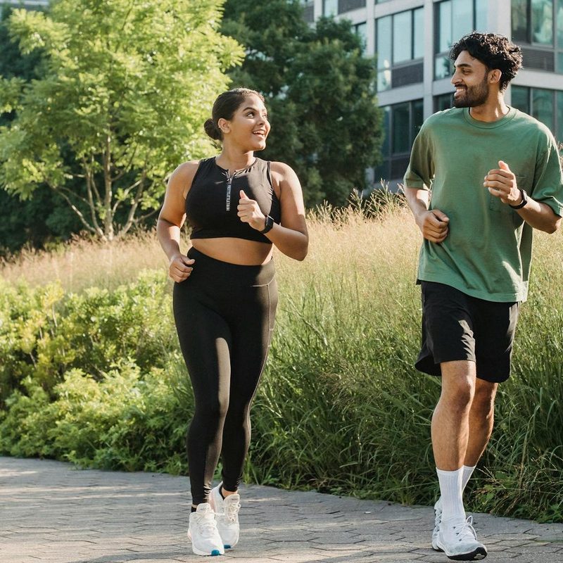 Man and woman running together runner high happy smile outdoors exercise workout