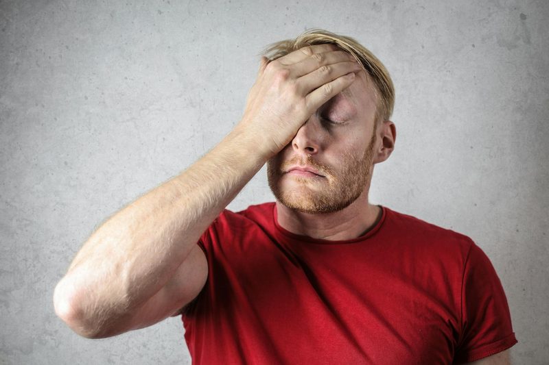 man stressed overwhelmed face palm head in hands