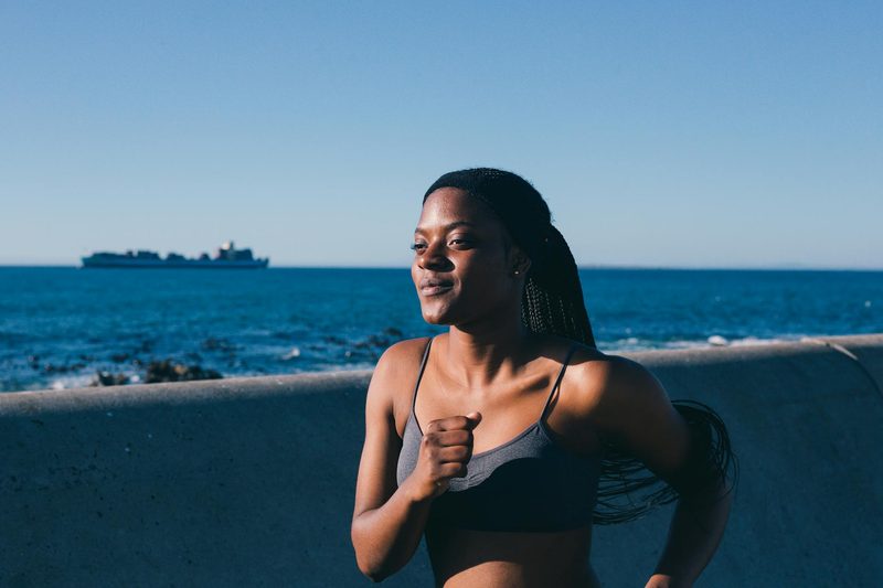 woman happy running smiling outside by water