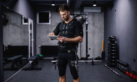 Man wearing EMS (electrical muscle stimulation) suit while working out