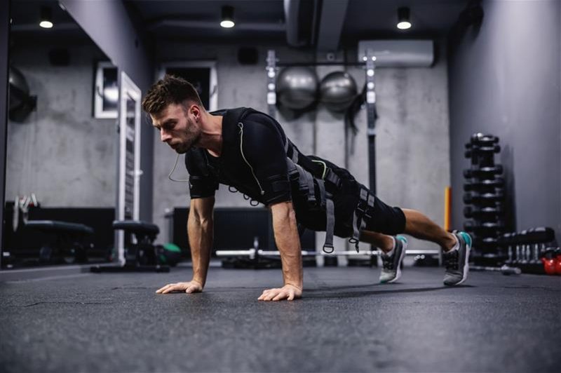 man wearing EMS suit working out push up plank press up.