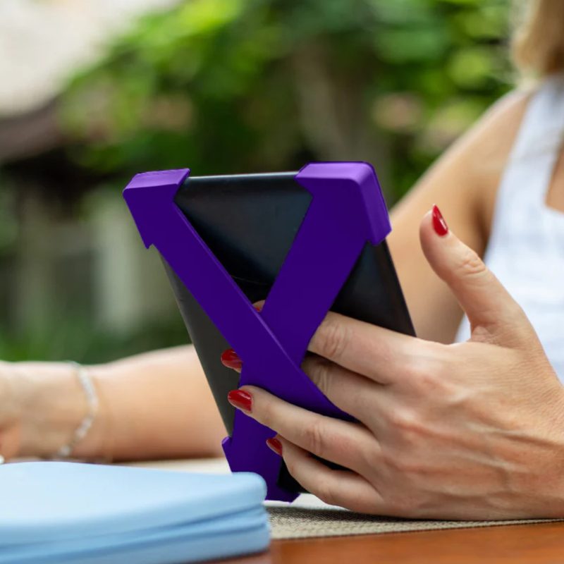 A woman using the Strapsicle while reading on a Kindle device