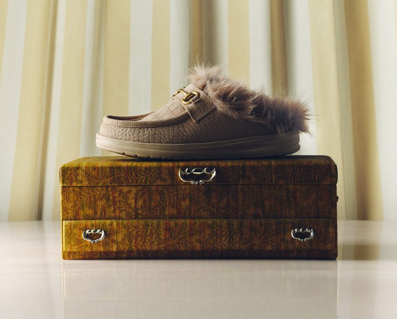 cream loafer on brown suitcase