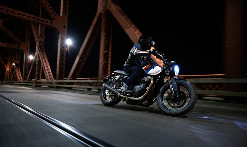 2025 Triumph Speed Twin 900 driving on a bridge.