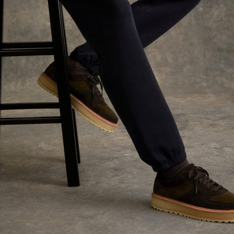 man sitting on stool wearing brown sneakers