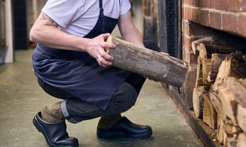 chef squatting in kitchen in clogs