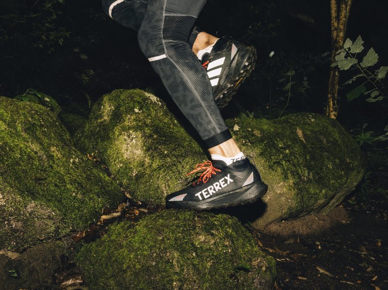 person stepping on rock in adidas hiking shoe