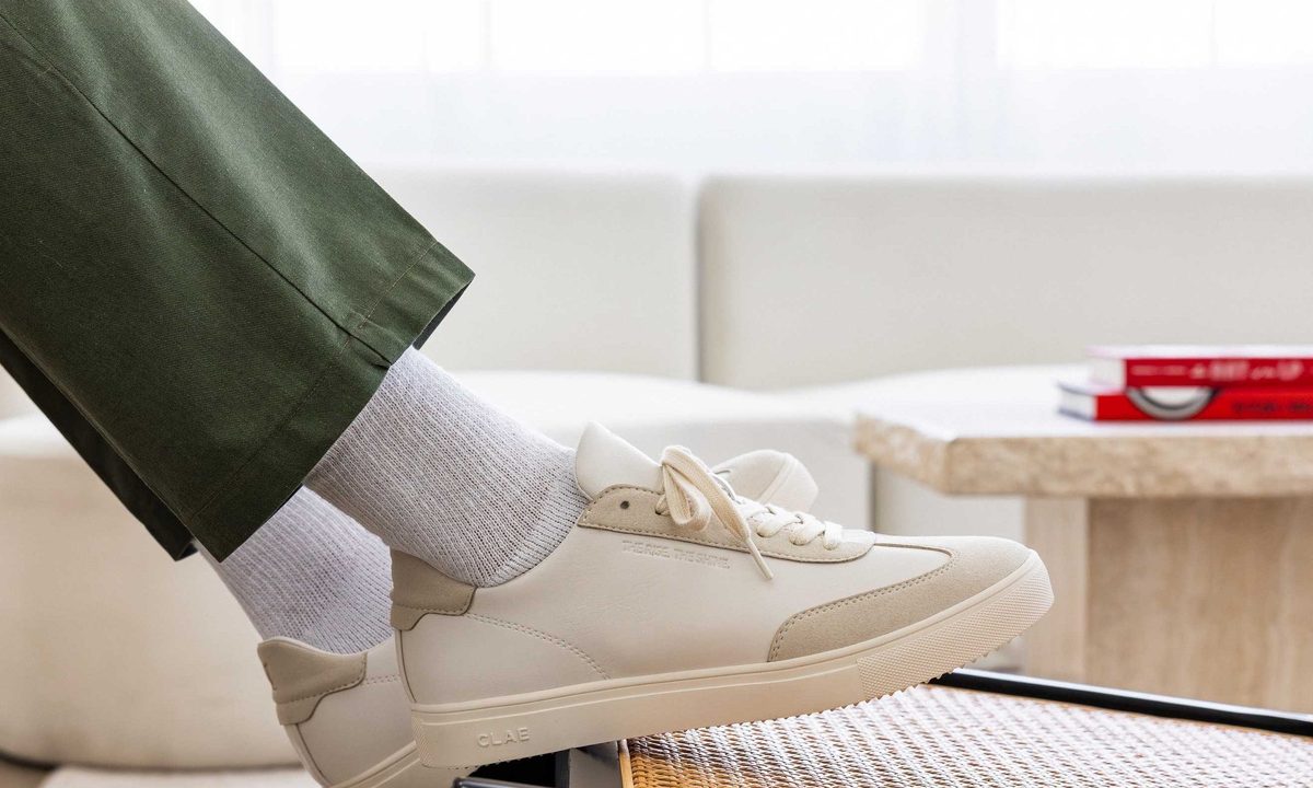 person setting foot on table with sneakers