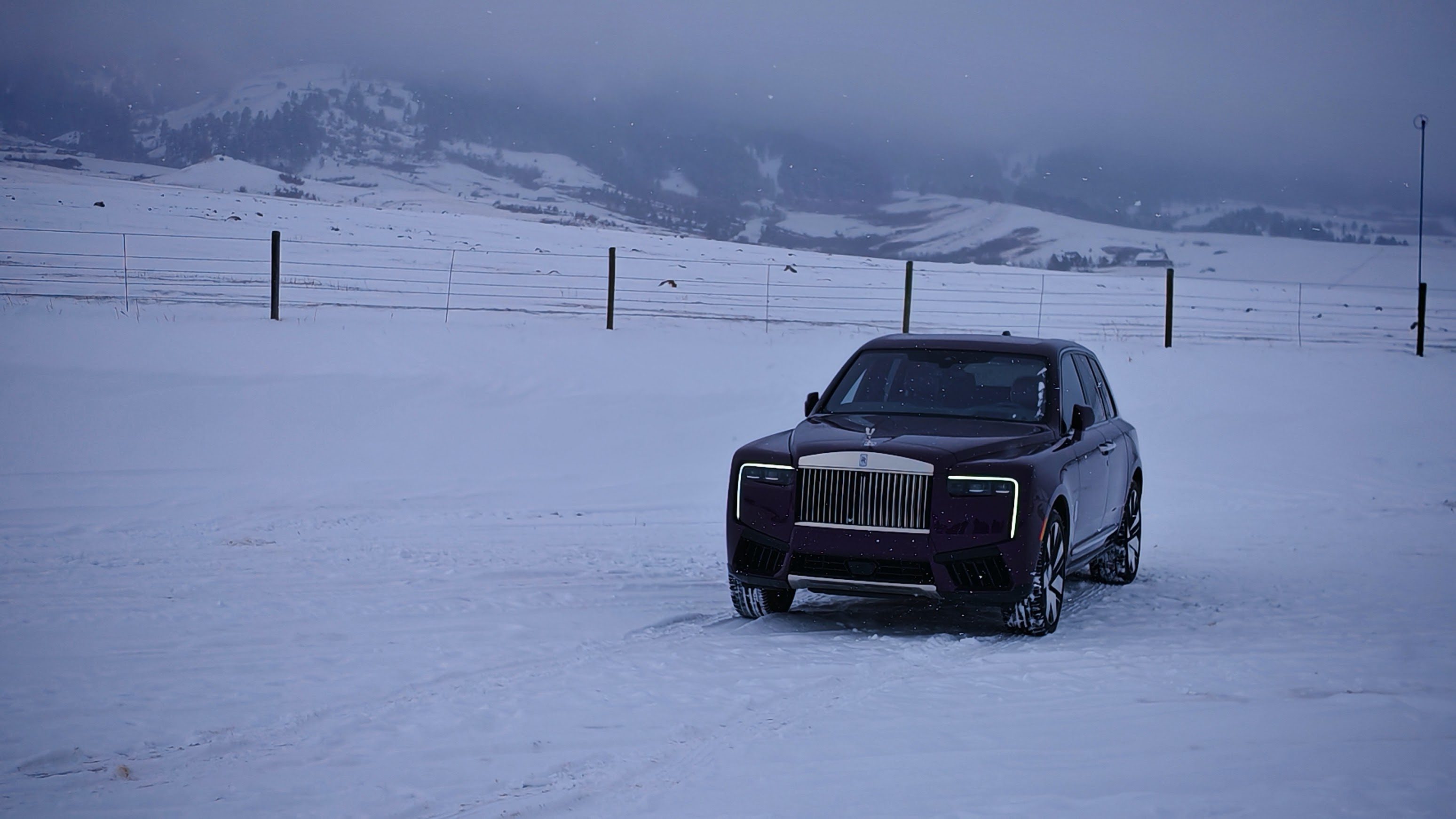 A black Rolls-Royce Cullinan with mountains in the background
