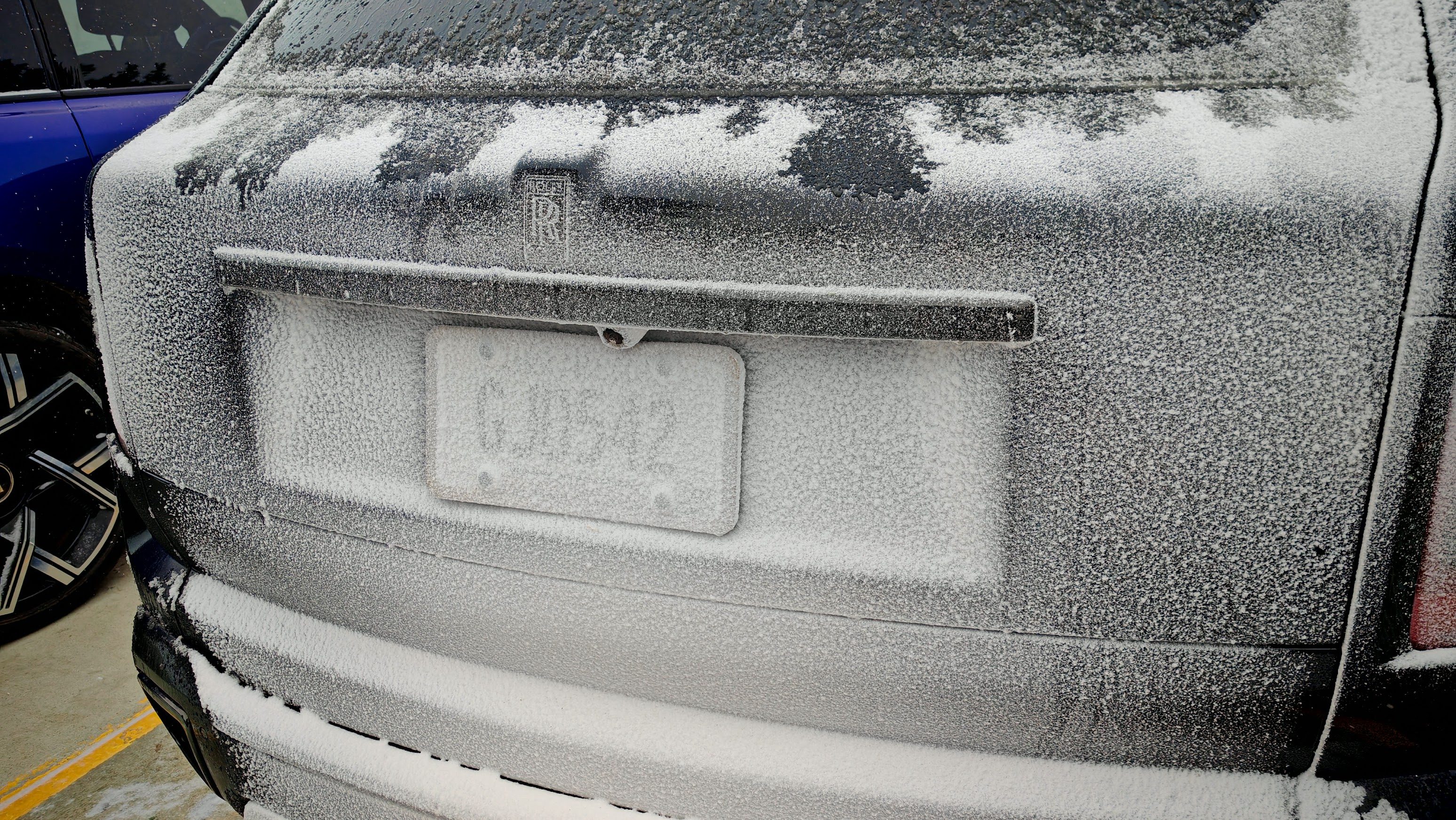 The snow-covered rear of a Rolls-Royce Cullinan