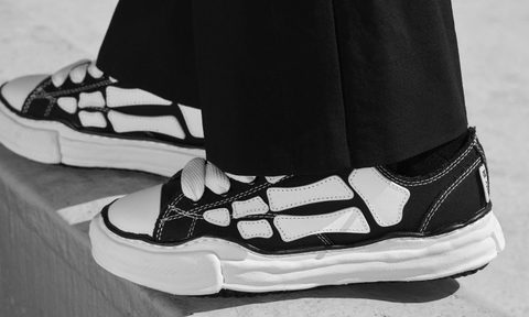 model wearing black amiri bones sneakers