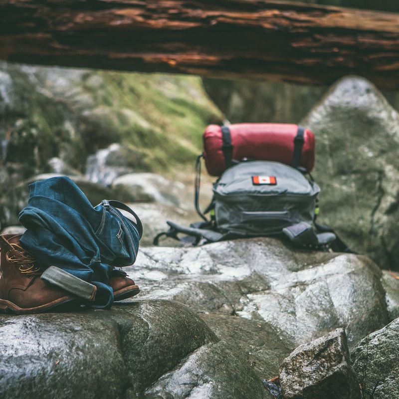 Two hiking backpacks on some wet trail rocks