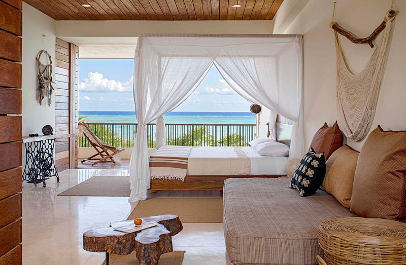 a bedroom at casa xixim with the ocean view in the back