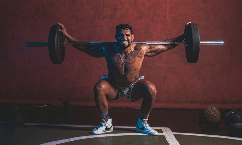 Man exercising hard pain barbell squat