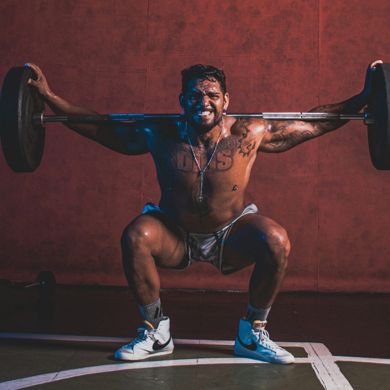 Man exercising hard pain barbell squat