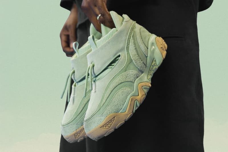 man holding mint green reebok sneaker