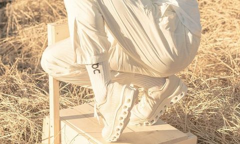 man standing on chair with white On sneakers