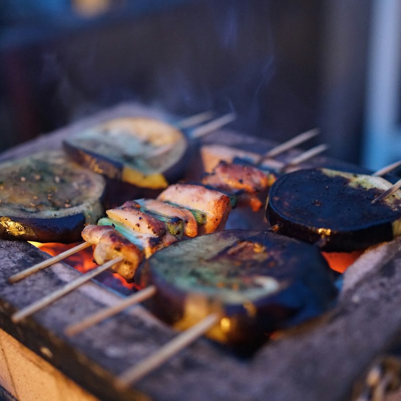 Cooking skewers over a grill while camping