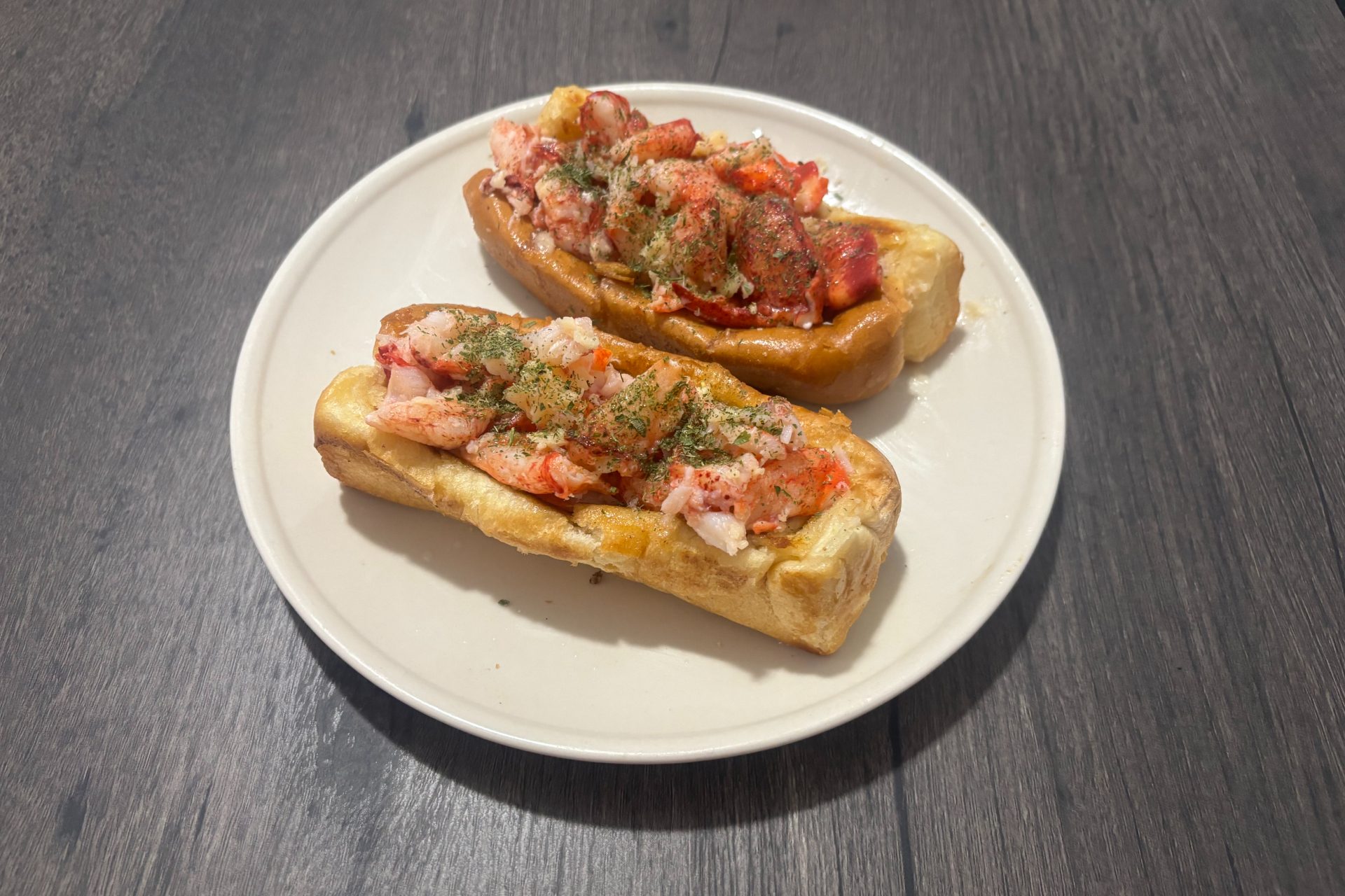 two lobster rolls on plate.