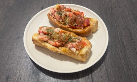 two lobster rolls on plate.