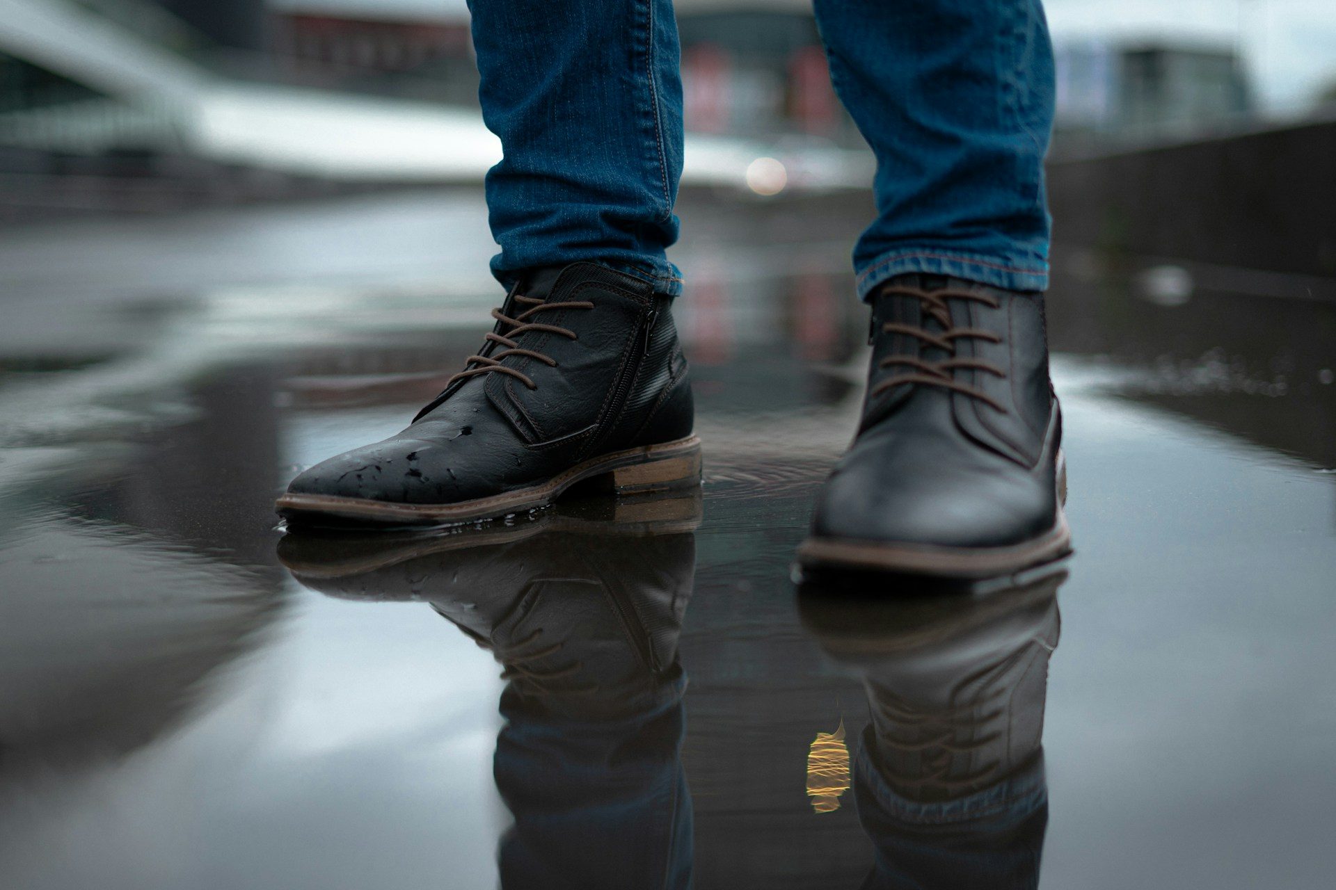 man wearing leather boots in rain puddle