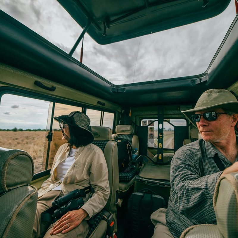 Man and woman sitting inside car on a safari